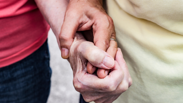 Closeup of two senior women holding hands.