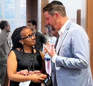 Senator Henry Stern speaks with Edith, a survivor of the Rwandan Genocide, after giving the opening remarks at the second annual Summer Institute.