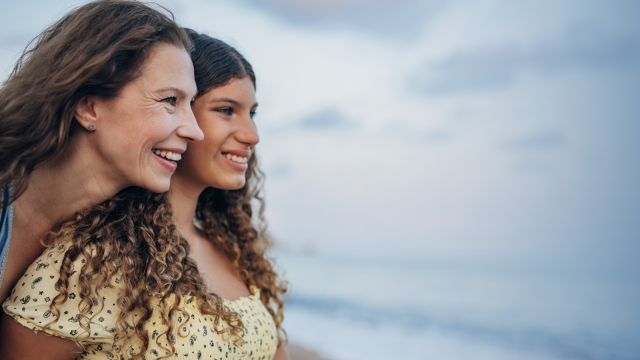 Teenage and girl and mother look out at the beach