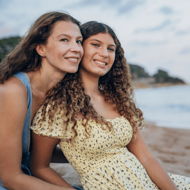 Mother and daughter relax on the beach.