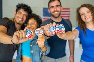 people holding "I voted" pins. 