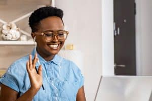 woman waiving at computer screen